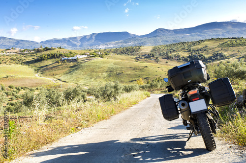 Motorbike on countryside road against of summer landscape, travel by bike