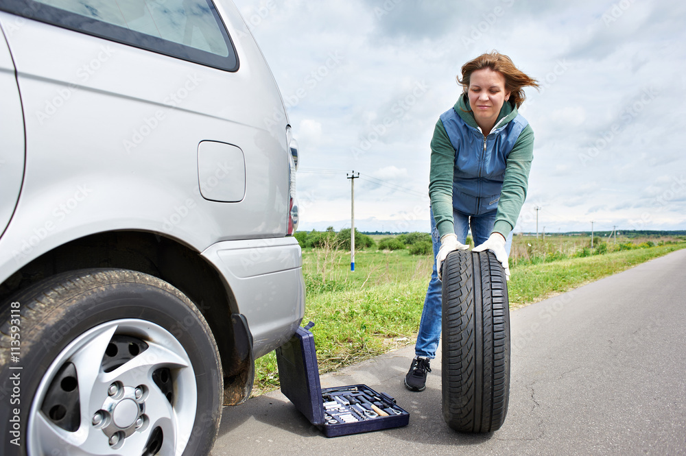 Woman changing wheel of car Woman changing wheel of car