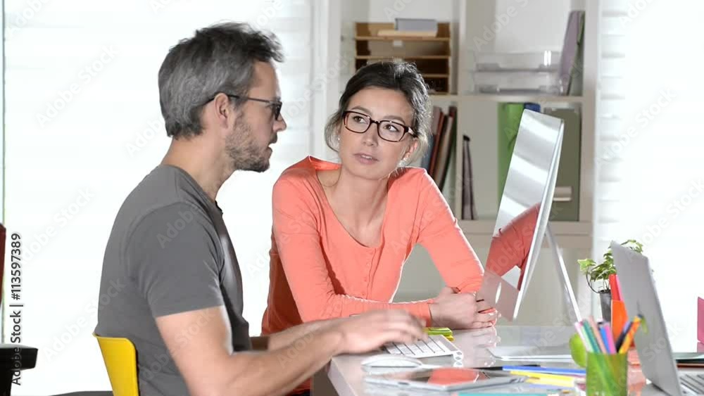 at office, nice couple working together at a computer at office, nice couple working together at a computer