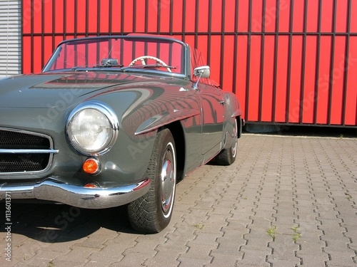 Offene Cabriolet Legende im Grau der Fünfziger Jahre in Dunkelgrau vor einem roten Industrietor beim Oldtimertreffen am Oldtimer-Park Lippe in Lage bei Detmold in Ostwestfalen-Lippe