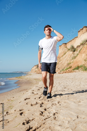 Sportsman walking along the beach