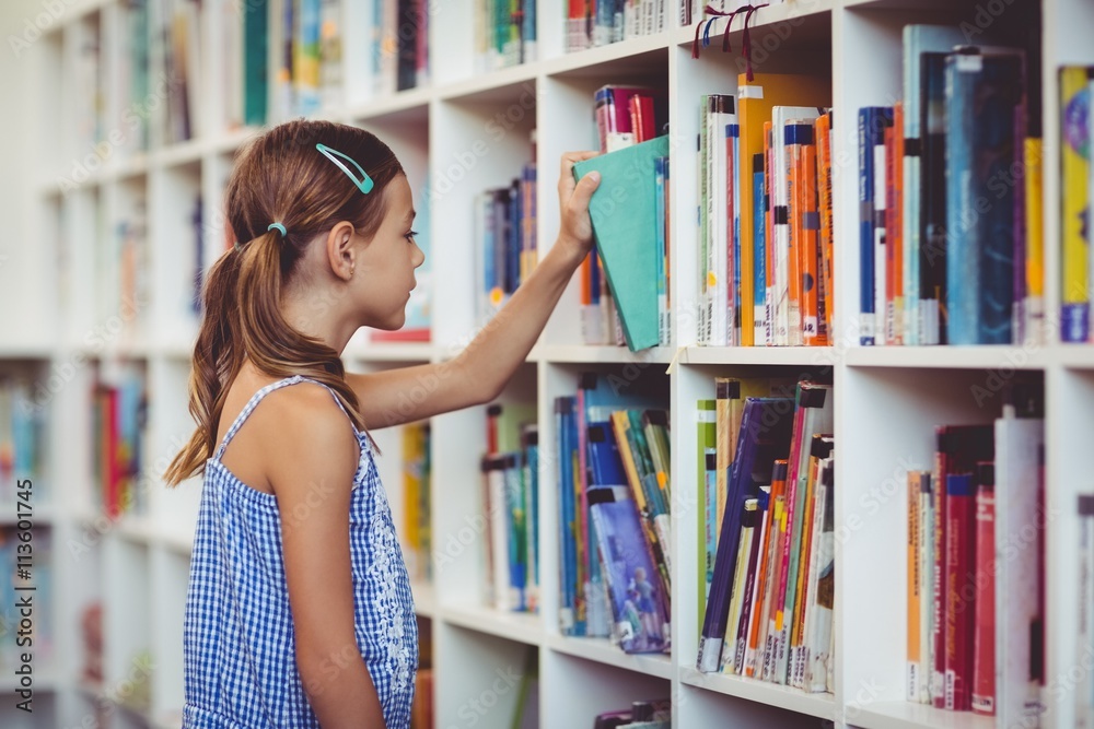 School girl taking a book from bookshelf in library School girl taking a book from bookshelf in library