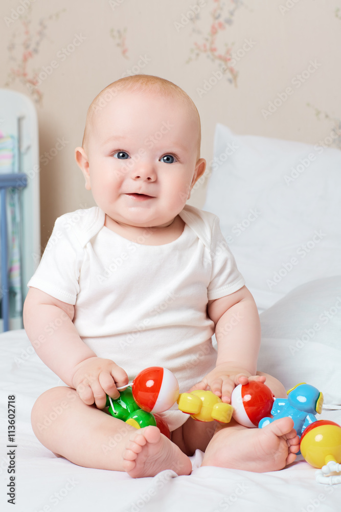 Cute smiling baby laughing and smiling with a toy in his hand. L Cute smiling baby laughing and smiling with a toy in his hand. L