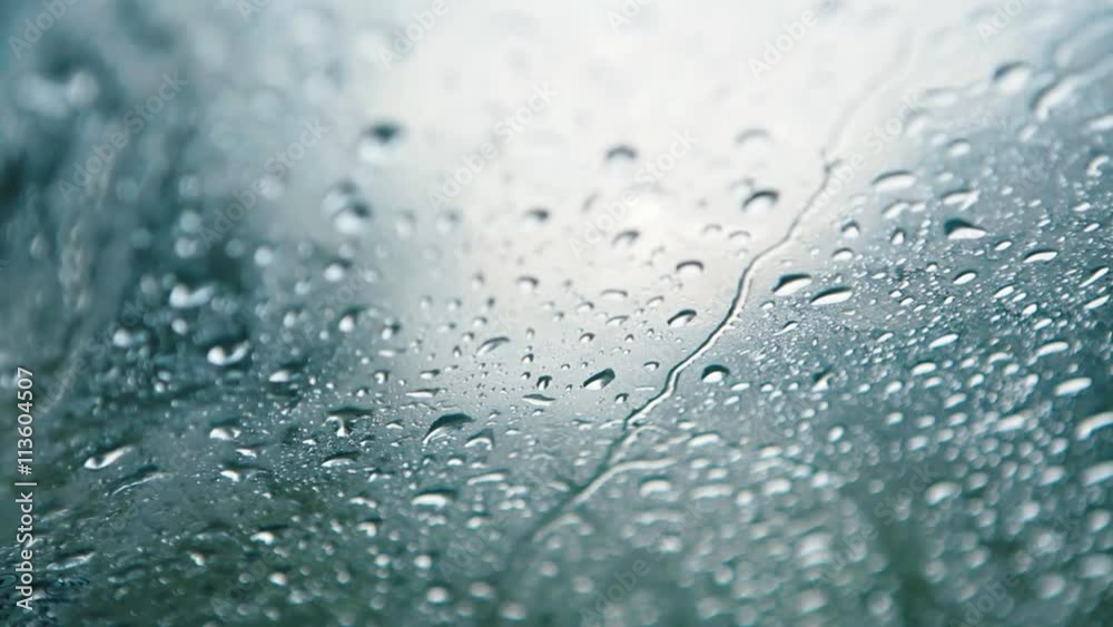 Rain falling on glass during rain storm.