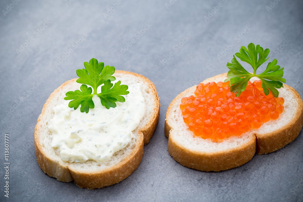 Bread with fresh cream cheese and red caviar on table. Bread with fresh cream cheese and red caviar on table.