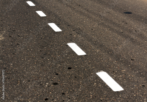 White road line on dirty asphalt texture.