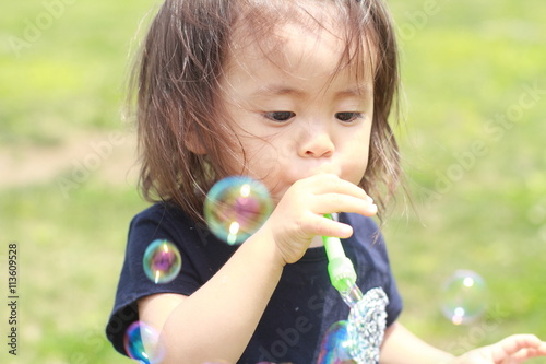 シャボン玉で遊ぶ幼児(1歳児)