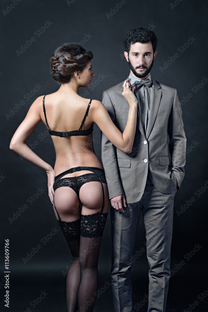 Beautiful lady in bra with handsome guy in suit. Young couple is hugging  each other. Portrait
