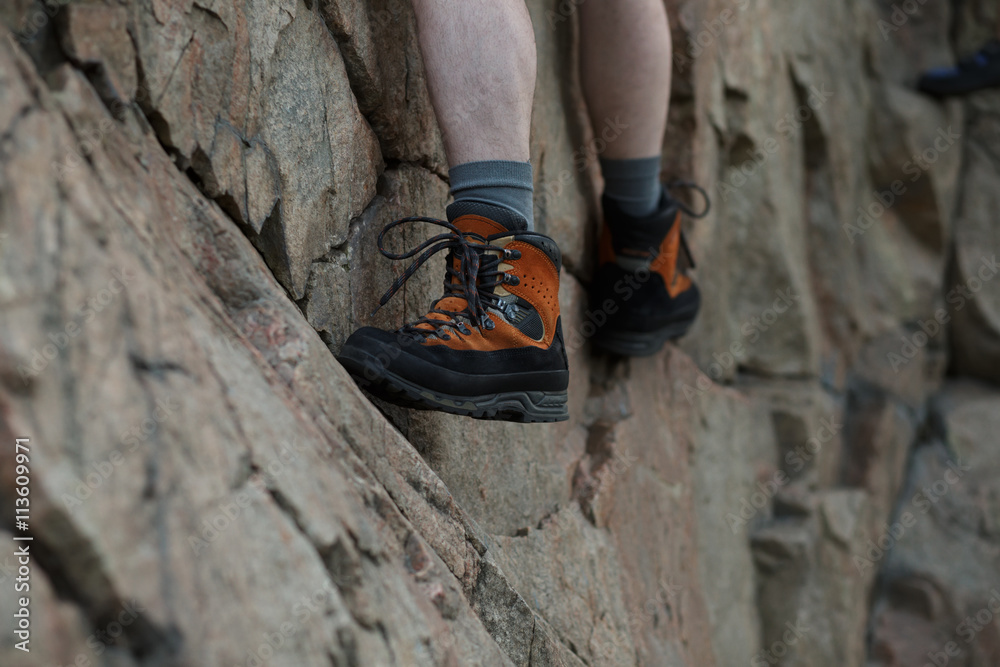 Legs of male rock climber clings to a cliff Legs of male rock climber clings to a cliff
