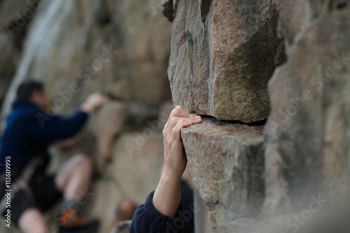 Slika na platnu Hand of male rock climber clings to a cliff