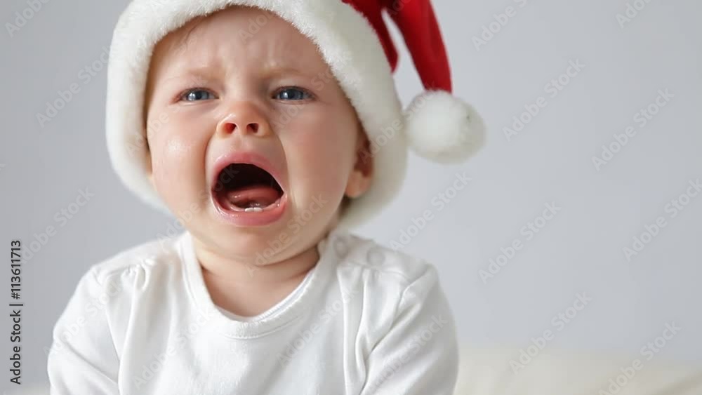 little baby with santas hat crying
