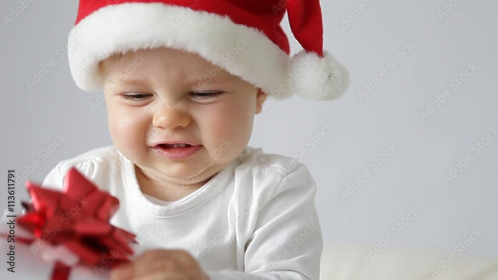 little baby with santas hat and a gift