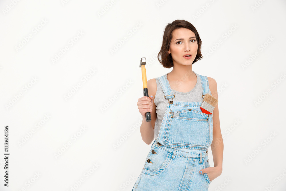 Portrait of young beautiful girl holding hammer keeping hand Portrait of young beautiful girl holding hammer keeping hand