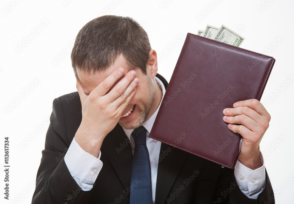Young businessman laughing and holding a book with money Young businessman laughing and holding a book with money