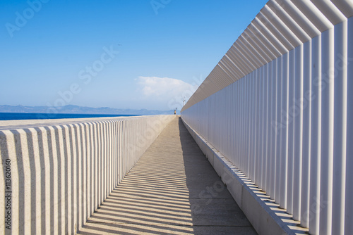 Spain, Andalusia, Tarifa, Light and shadows created by a fence on a concrete surface photo