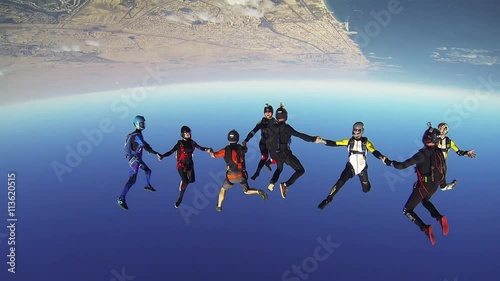 Professional skydivers parachuting above Dubai, dancing together in sky. Extreme srunt