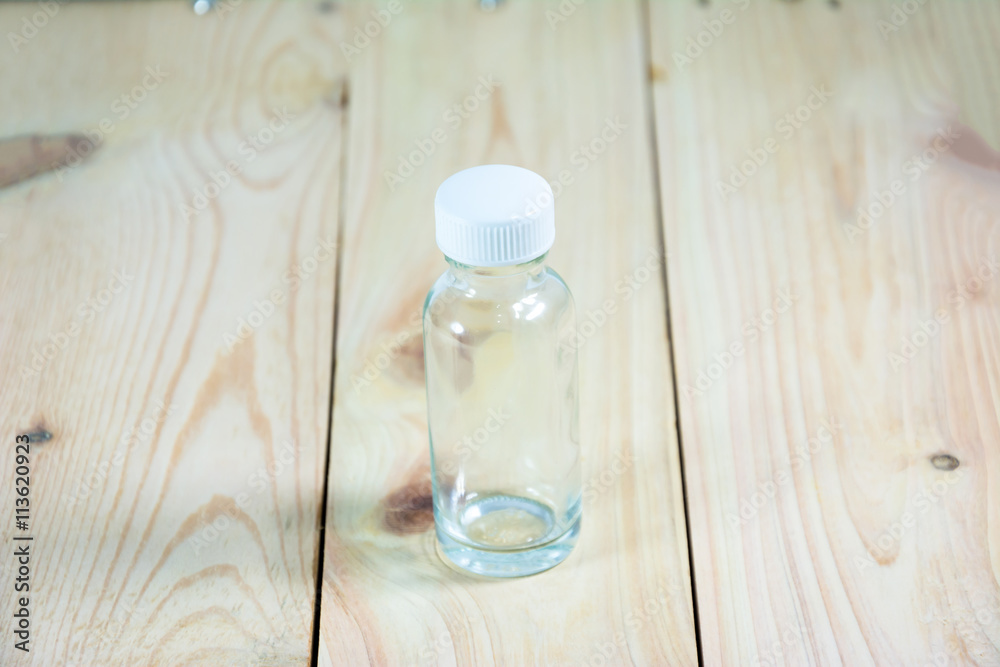 clear glass single bottle on wood pattern background