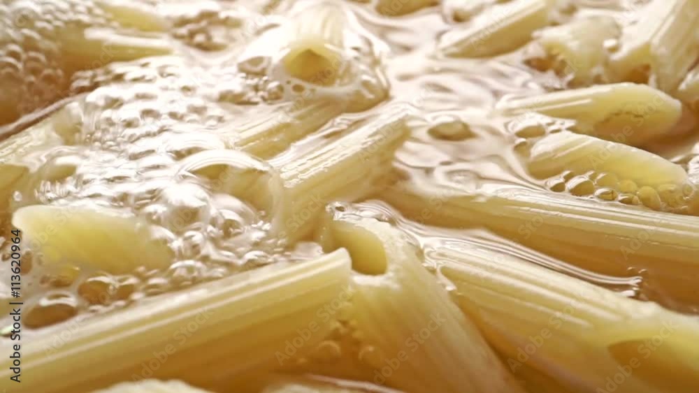 Pasta (penne) in boiling water, close up dolly shot Pasta (penne) in boiling water, close up dolly shot