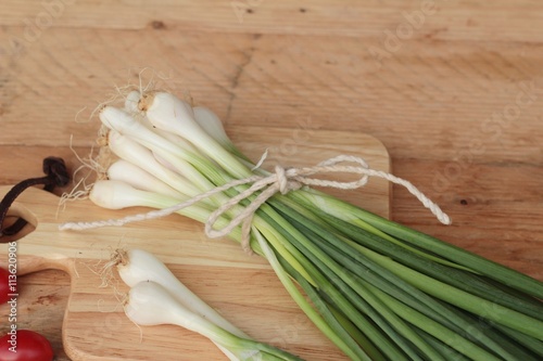 Fresh green onions on wood background.