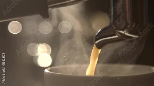 Coffee flows from cofee machine in slow motion photo