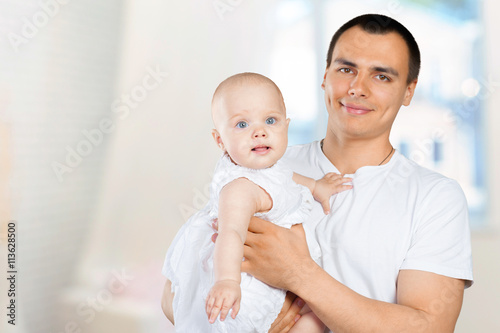 Happy young man holding a baby