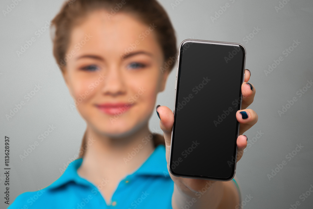 Smiling young woman showing blank smartphone screen Smiling young woman showing blank smartphone screen