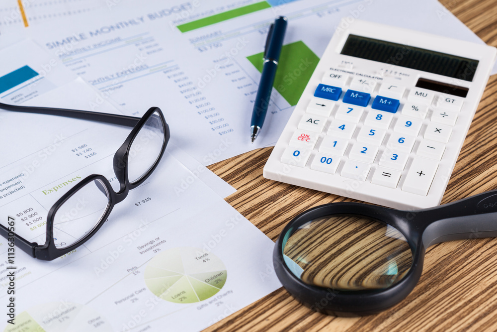 work with a magnifying glass, a calculator and papers work with a magnifying glass, a calculator and papers
