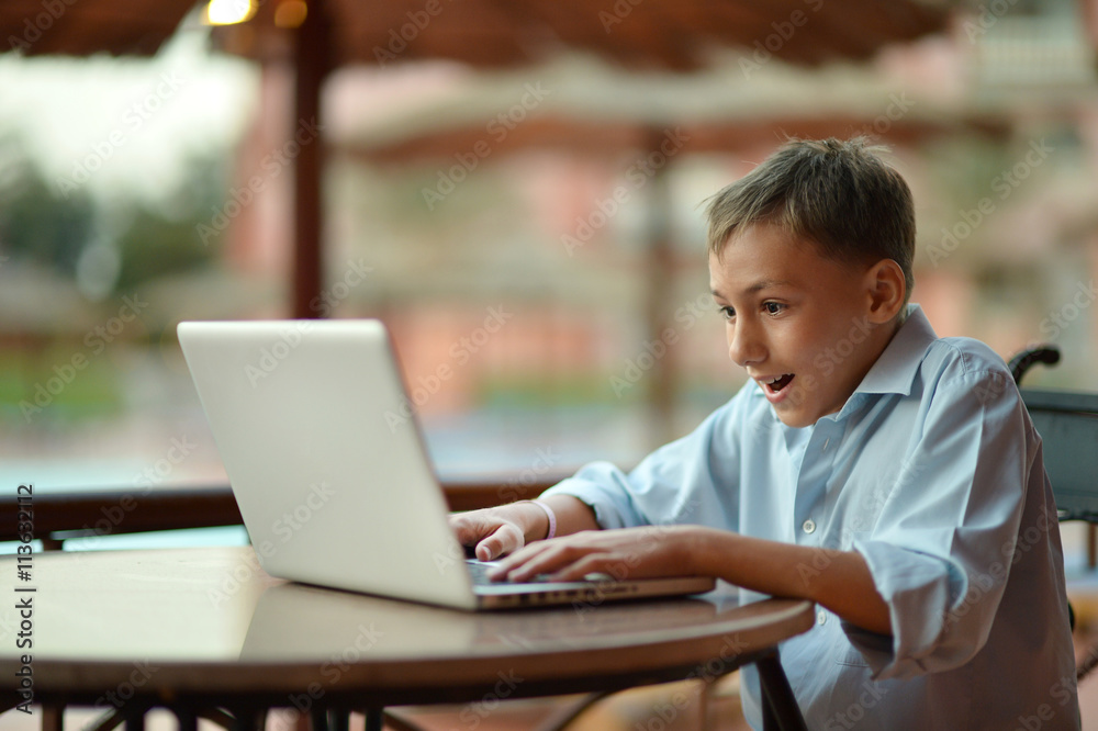 boy with laptop on table boy with laptop on table