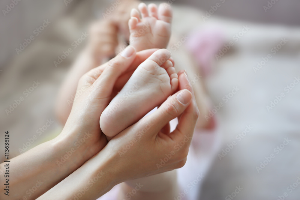 Woman holding small baby feet Woman holding small baby feet