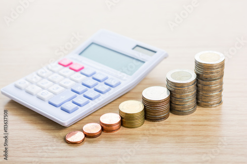 Calculator and money thai coins ( bath) staircase sorted on wood