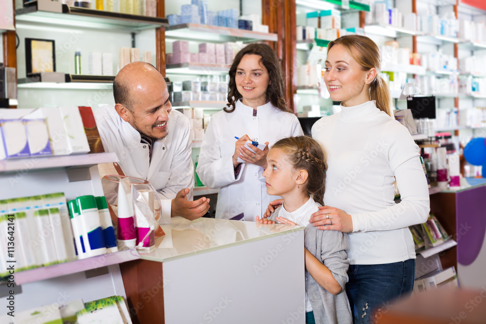 Obraz premium Mother with a girl in the pharmaceutical store
