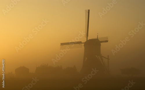 Foggy sunrise near the Wingerdse mill in Bleskensgraaf in the Dutch region Alblasserwaard 