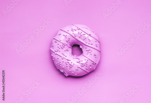 Pink glaze / Creative photo of a painted pink donut on pink background. photo