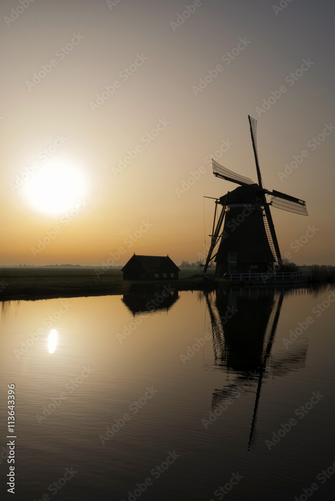 Achtkante mill near Groot-Ammers in the Dutch region Alblasserwaard in backlight
