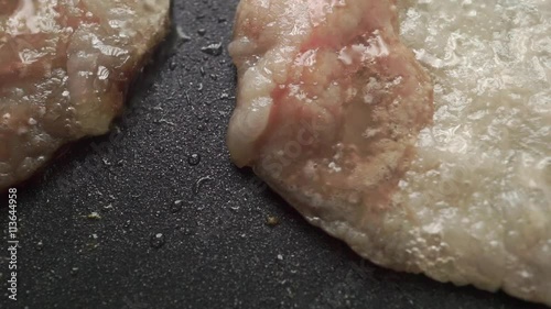 Frizzling bacon on a non stick frying pan, macro video photo