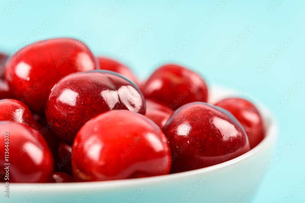 White Bowl Of Fresh Red Cherries On Turquoise Background White Bowl Of Fresh Red Cherries On Turquoise Background
