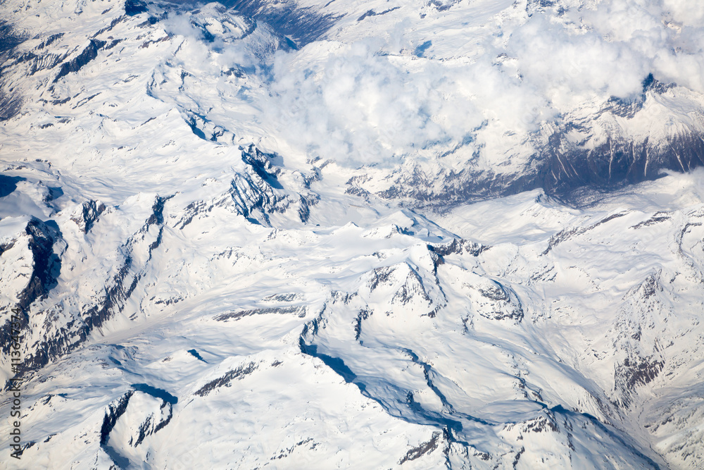 Alps with snow view through the white clouds Alps with snow view through the white clouds