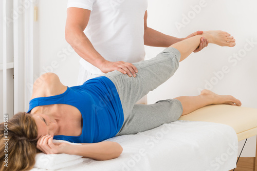Male Therapist Giving Leg Massage To Woman