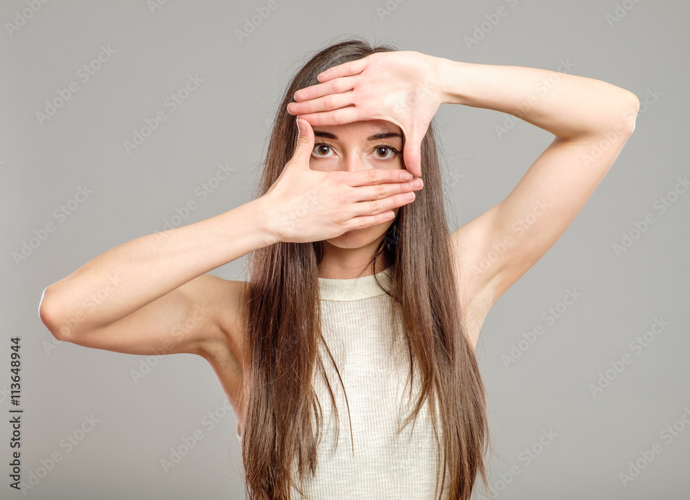 Serious woman creating a frame with fingers Serious woman creating a frame with fingers