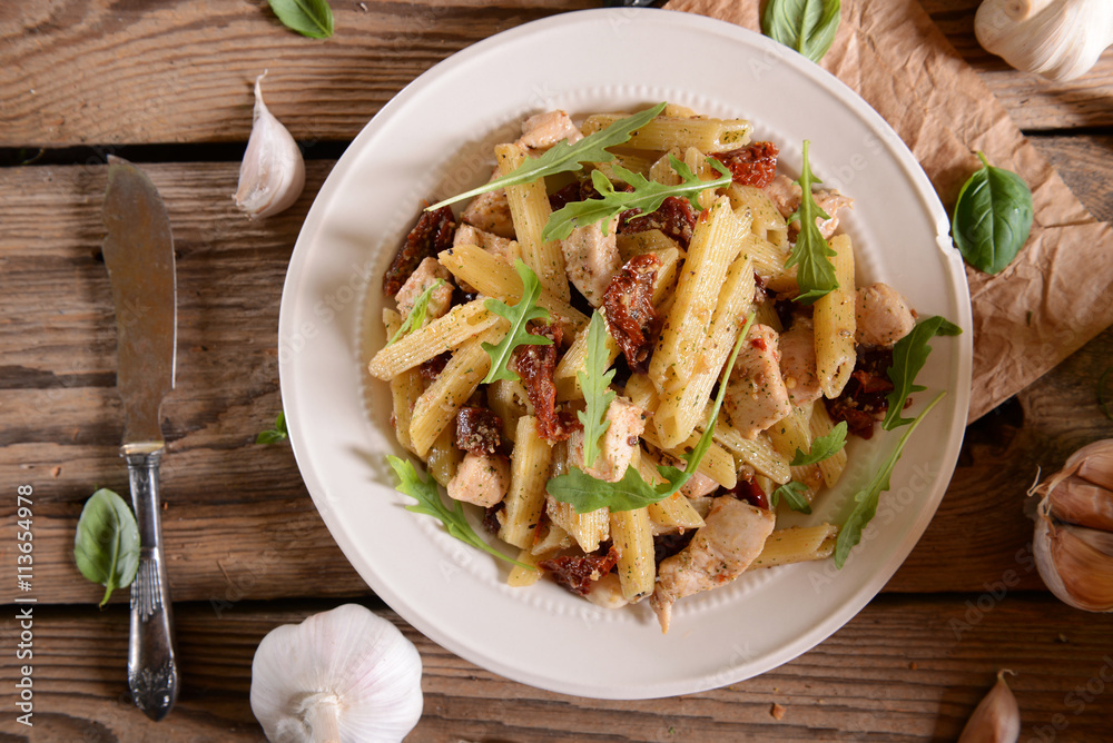 Penne pasta with chicken, dried tomatoes and ruckola