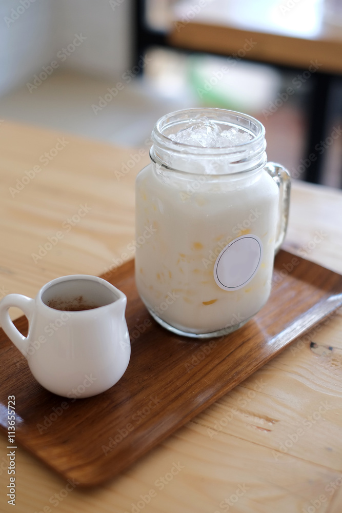 Pouring cocoa syrup on glass mug, iced cocoa menu.