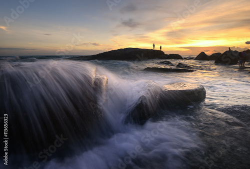 Evening light sunset sea waves splashing rocks.