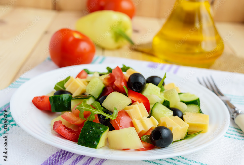 Fresh diet salad with cucumbers, tomatoes, olives cheese, bell peppers, arugula on a light wooden background