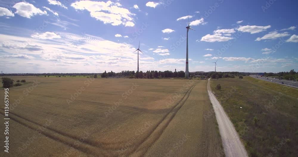 Aerial view of wind power turbines against blue sky wind clouds in Germany Aerial view of wind power turbines against blue sky wind clouds in Germany
