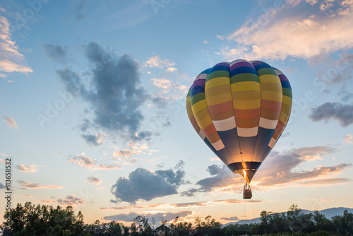 hot air balloon is flying at sunrise