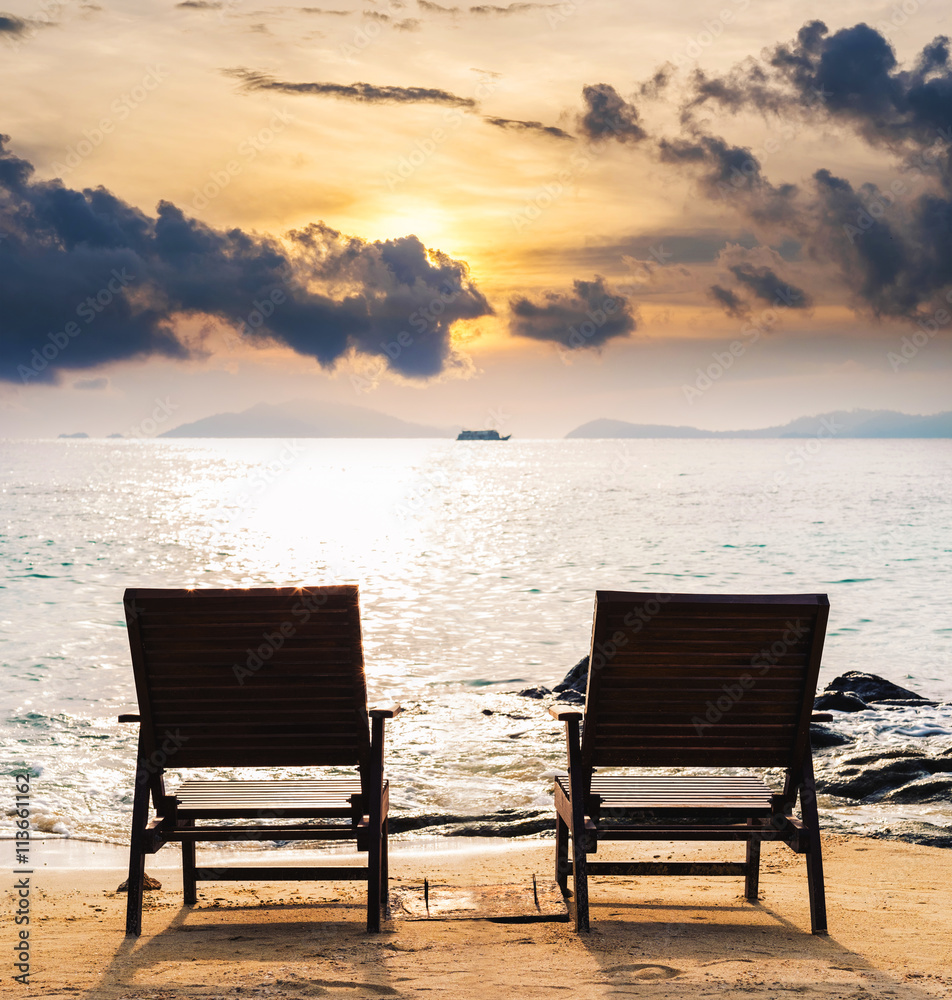 Two chairs on the beach in sunset, couple summer holiday vacation concept