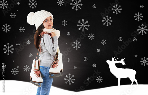 Little girl with skates in trendy knitted clothes and drawn snowflakes on blackboard background photo