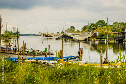 ships and fishing huts in the quiet of brackish lagoon