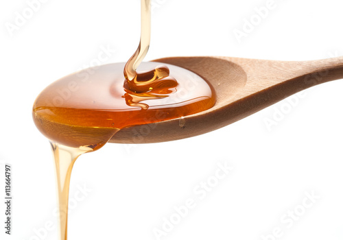 syrup pouring on spoon on white background