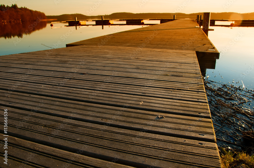 Wooden jetty at lake, photographed in the evening, sunset in sum